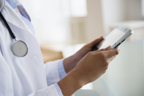 Mixed race doctor using digital tablet