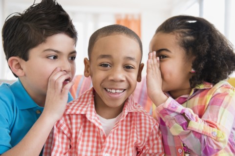 Children whispering into friend's ears