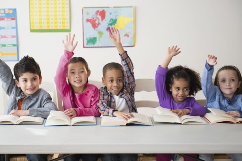 Students raising hands in classroom