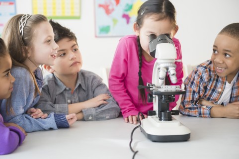 Students using microscope in classroom
