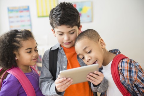 Students using digital tablet in classroom