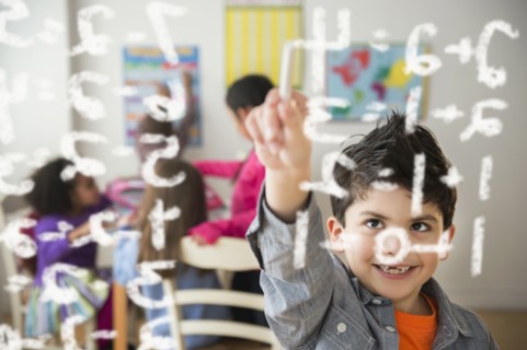 Boy doing math problems in classroom