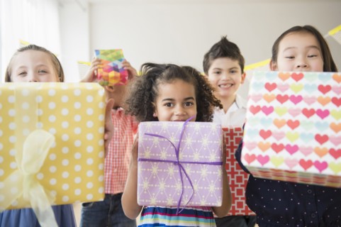 Children holding birthday presents at party