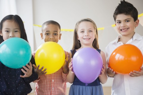 Children holding colorful balloons at party