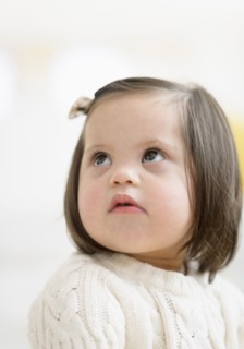 Hispanic toddler with Down syndrome looking up