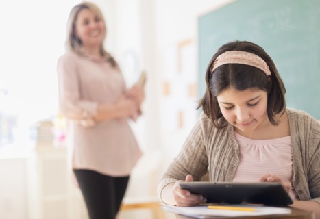 Hispanic girl using digital tablet in classroom