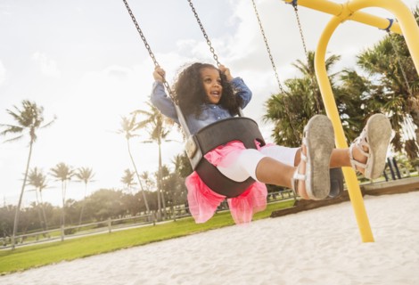 Mixed race girl playing on playground