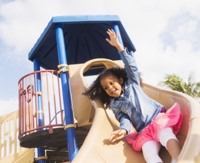 Mixed race girl playing on playground