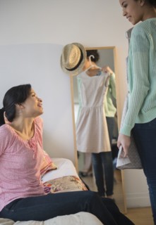 Mother helping daughter choose dress