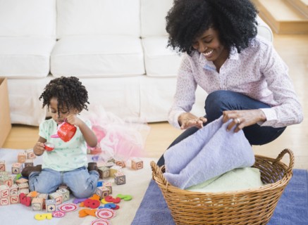 Mother folding laundry while daughter plays