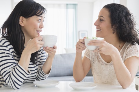 Women drinking coffee together at table