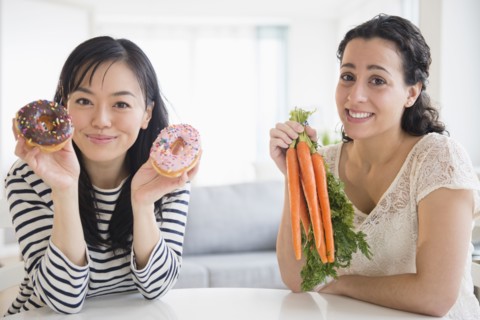 Women choosing between donuts and carrots