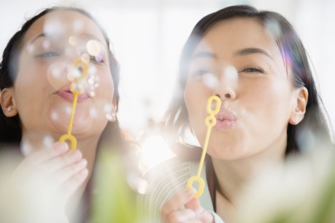 Women blowing bubbles together