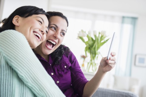 Women taking picture together in living room