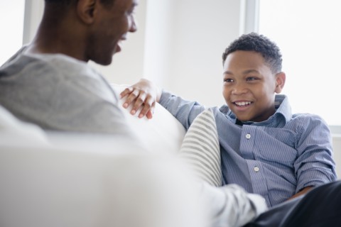 Father and son relaxing on sofa