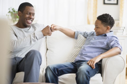 Father and son relaxing on sofa