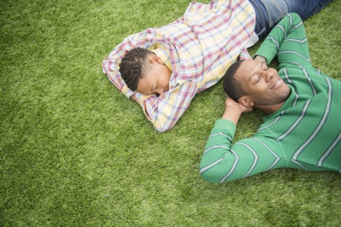 Father and son relaxing in grass