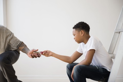 Boy giving father pliers