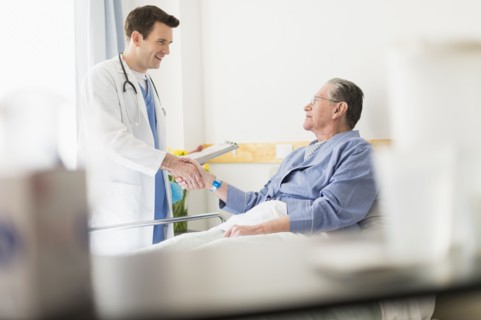 Caucasian doctor shaking hands with Senior patient in hospital