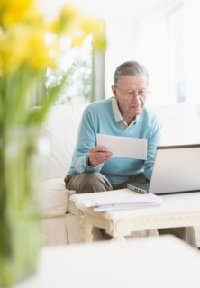 Senior Caucasian man paying bills online