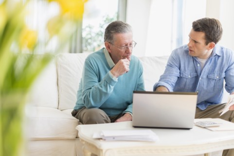 Caucasian man helping father use computer
