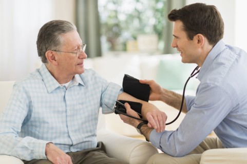 Caucasian doctor taking patient's blood pressure at home
