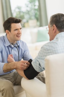 Caucasian doctor taking patient's blood pressure at home