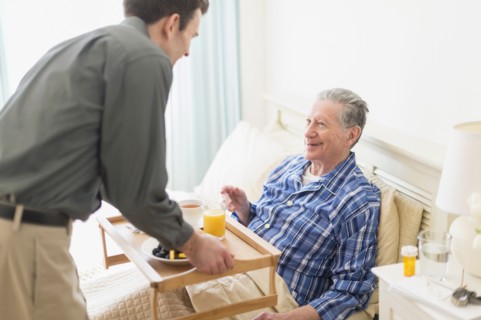 Senior Caucasian man having breakfast in bed