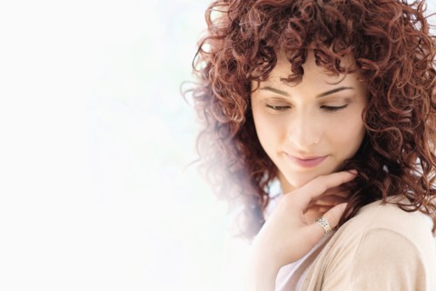 Hispanic woman holding chin in hands