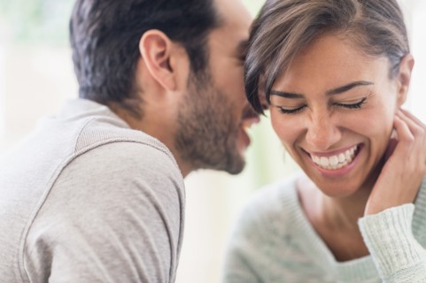 Couple whispering together indoors