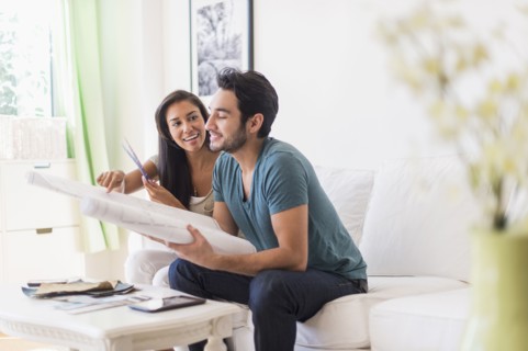 Couple examining blueprints in living room