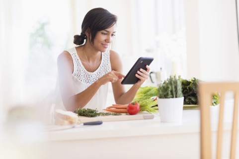 Hispanic woman cooking with digital tablet