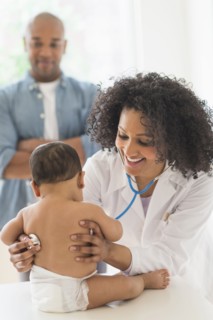 Doctor giving baby a check up in office