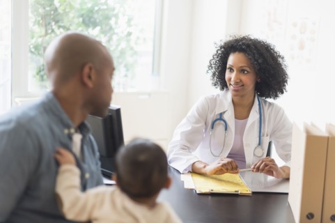 Father with baby talking to doctor