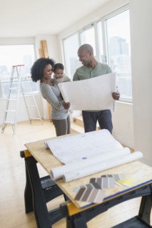 Family examining blueprints in new home