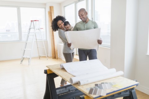 Family examining blueprints in new home