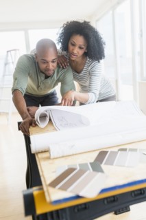 Couple examining blueprints of new home