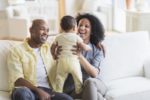 Parents playing with baby in living room