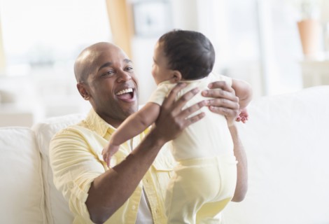 Smiling father playing with baby