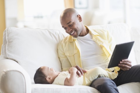 Smiling father playing with baby