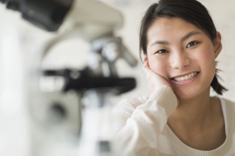 Mixed race teenage girl smiling in science lab