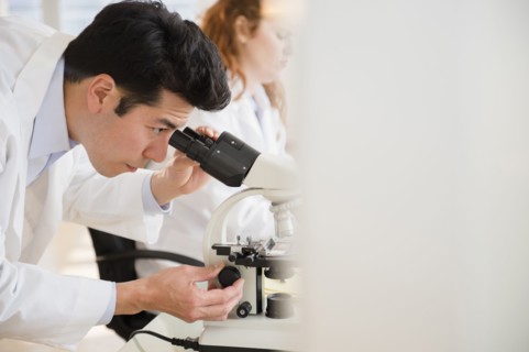 Scientist using microscope in lab