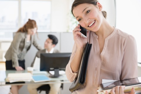 Businesswoman talking on cell phone in office