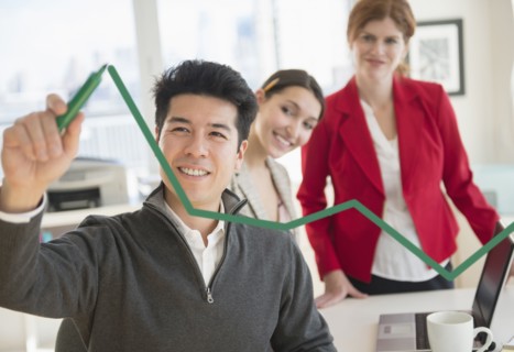 Businessman drawing graph on window in office