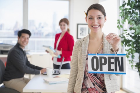Businesswoman holding Open sign in office