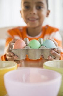 Mixed race boy dyeing Easter eggs