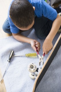 Mixed race boy fixing skateboard
