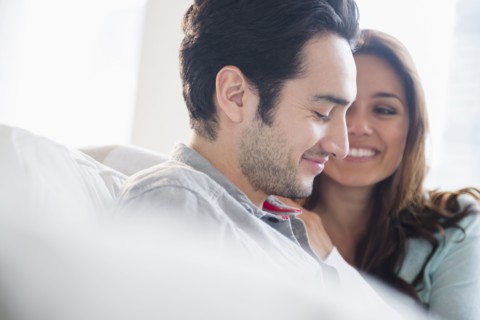 Couple smiling together on sofa