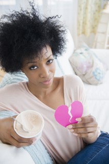African American woman holding broken heart and ice cream