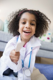 African American girl playing doctor in living room
